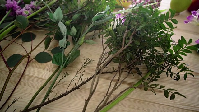桌上放着几枝绿叶和粉红色的花朵视频素材画面2