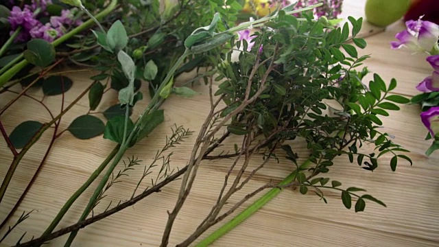 桌上放着几枝绿叶和粉红色的花朵视频素材画面3