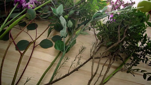 桌上放着几枝绿叶和粉红色的花朵视频素材画面4