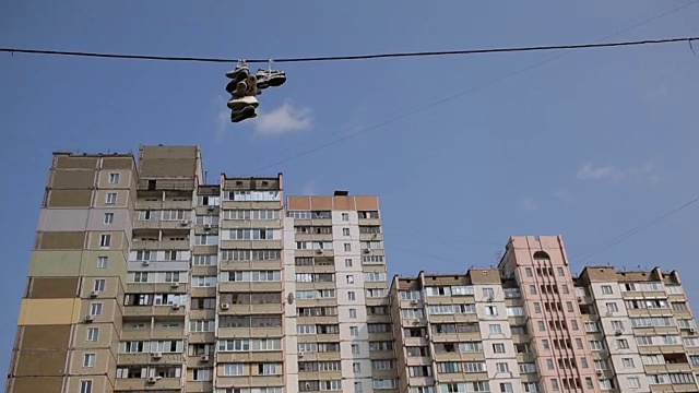 旧鞋挂在宿舍区电线上，有毒贩的标志视频素材画面1