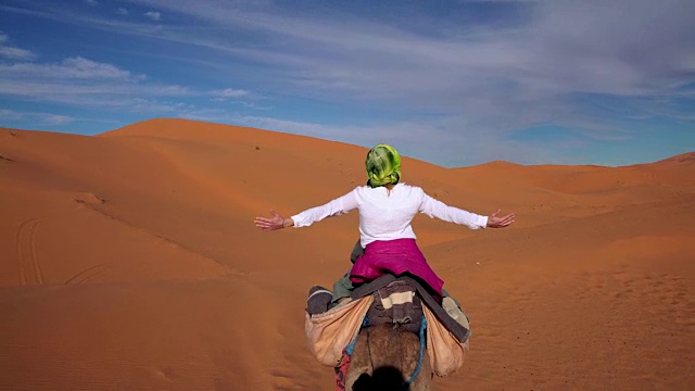 沙漠之旅。女人喜欢骑骆驼视频素材画面1