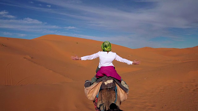 沙漠之旅。女人喜欢骑骆驼视频素材画面3