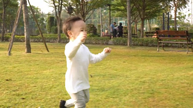 小男孩在花园里奔跑，慢镜头视频素材画面2