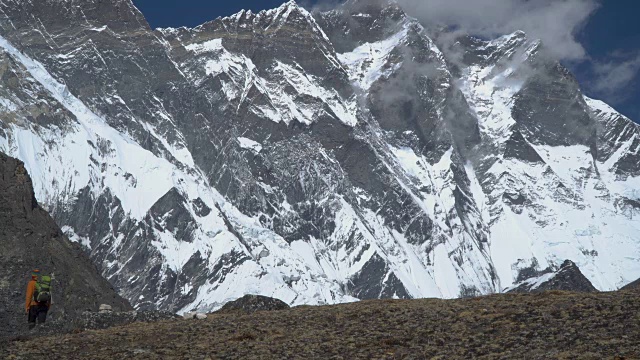 一个背着背包的男人爬上了喜马拉雅山的山坡视频素材