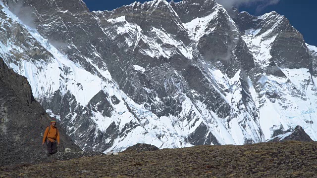 一个背着背包的男人爬上了喜马拉雅山的山坡视频素材