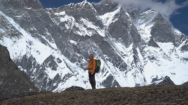 一个背着背包的男人爬上了喜马拉雅山的山坡视频素材