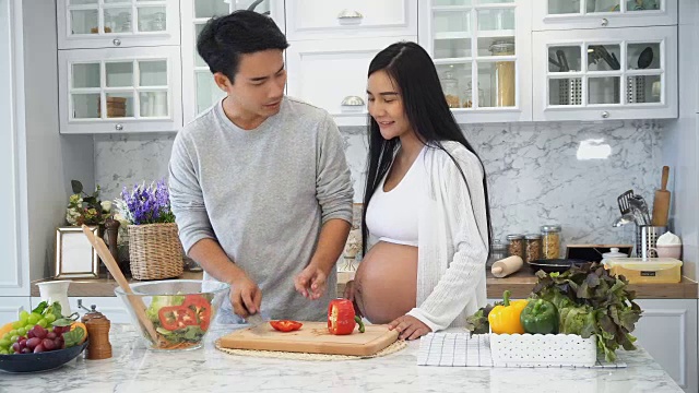 年轻的丈夫为怀孕的妻子做饭视频素材