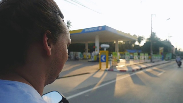 一名男子在热带岛屿上驾驶摩托车，在美丽的日落慢镜头中旅行。泰国。方向盘的视图。1920 x1080视频素材