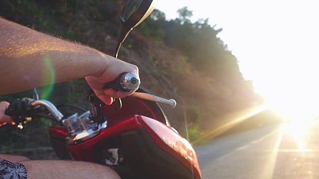 男子驾驶摩托车向太阳在热带岛屿上，而旅行在美丽的日落在缓慢的动作。假期的概念。1920 x1080视频素材