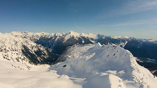 飞越锯齿状的雪山山峰北喀斯喀特山脉揭示巨大的山谷贝克湖令人兴奋的鼓舞人心的自然镜头视频素材