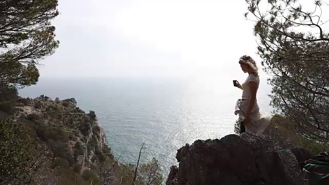 一名女性徒步旅行者在海岸线上的日出前停下来视频素材