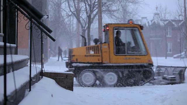 下雪期间的汽车和人行道扫雪机视频素材