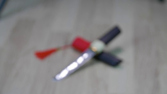 锋利的tanto与木制把手躺在鞘与红色流苏。视频素材画面2