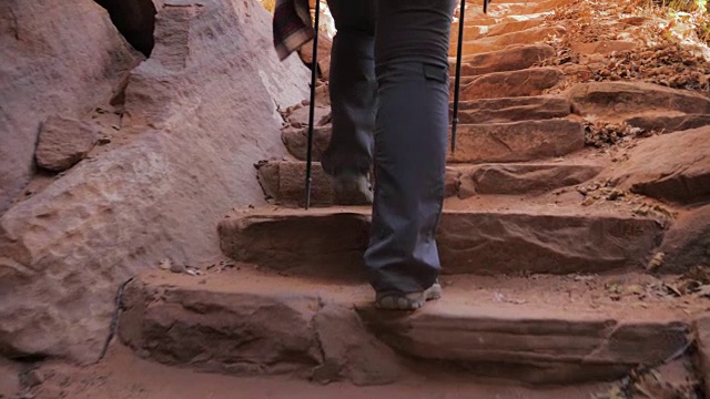 女人的脚艰难地攀登红色峡谷的石阶视频素材