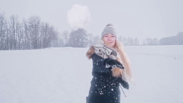 好玩的女人朝镜头扔雪球，超级慢动作视频素材