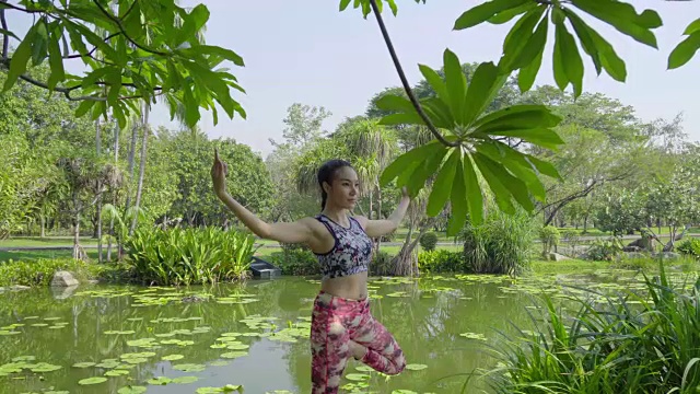 年轻女子在公园里做瑜伽运动视频素材