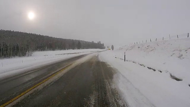 阴天冬季在冰雪覆盖的公路上驾驶视频素材