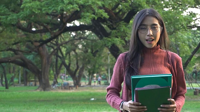 学生拿着学习书籍在大学公园。视频素材