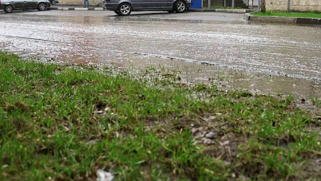 汽车在雨中行驶在被洪水淹没的道路上，慢镜头。视频素材