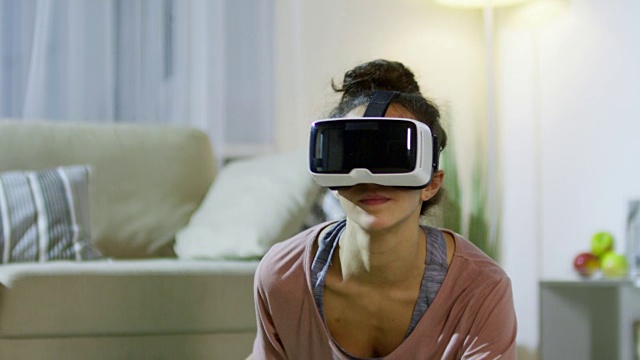 戴着VR眼镜做劈叉的女人视频素材画面3
