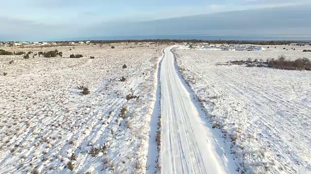 爱沙尼亚，北欧森林中覆盖着积雪的空旷道路的鸟瞰图。视频素材