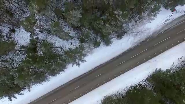 爱沙尼亚雪地森林中一条空旷道路的鸟瞰图。视频素材