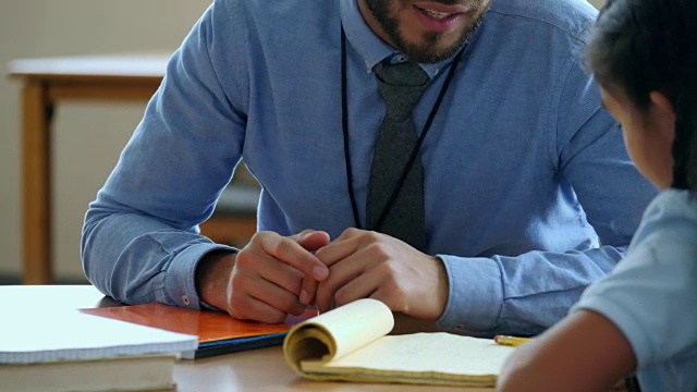 男小学教师帮助女学生视频素材