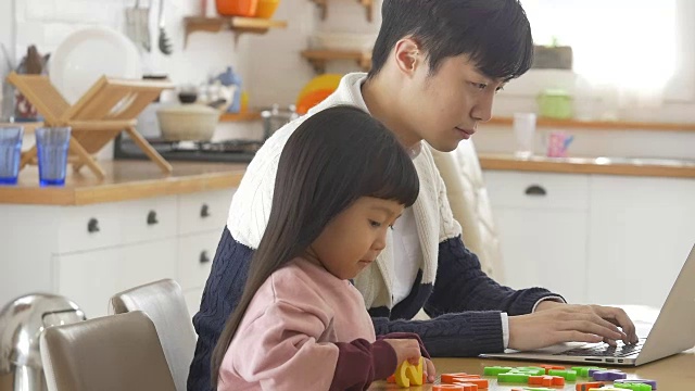 一个韩国爸爸和一个女儿坐在桌子上视频素材画面1