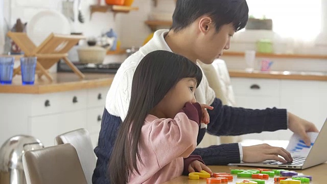一个韩国爸爸和一个女儿坐在桌子上视频素材画面2