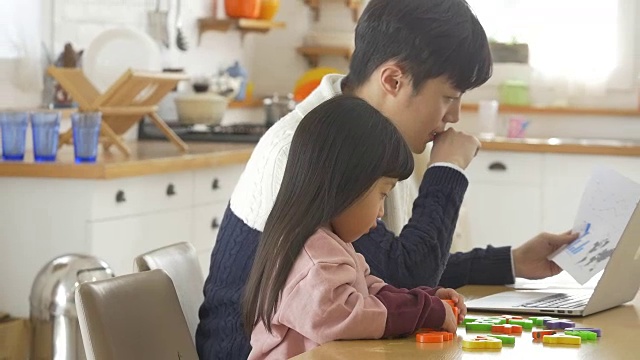 一个韩国爸爸和一个女儿坐在桌子上视频素材画面2