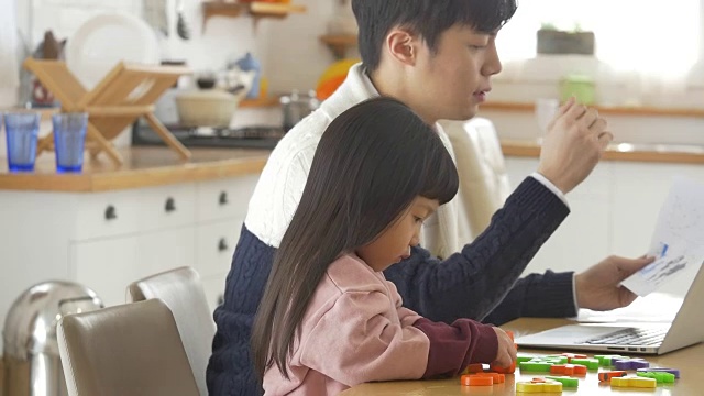 一个韩国爸爸和一个女儿坐在桌子上视频素材画面3