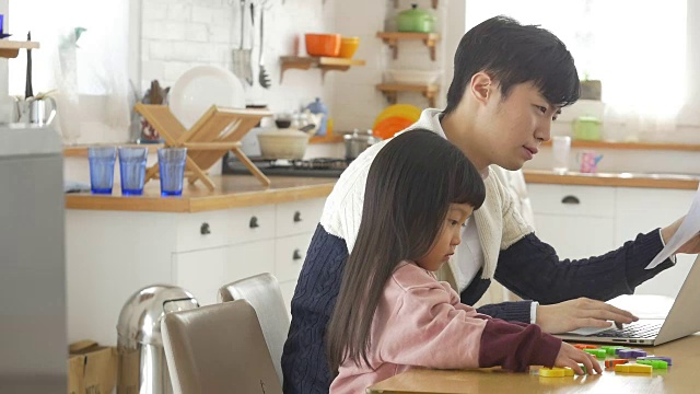 一个韩国爸爸和一个女儿坐在桌子上视频素材画面1