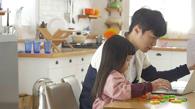 一个韩国爸爸和一个女儿坐在桌子上视频素材画面2