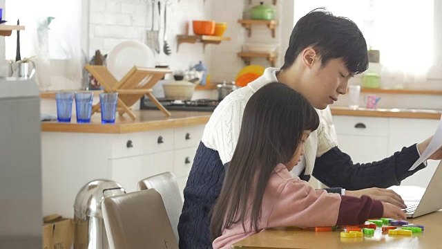一个韩国爸爸和一个女儿坐在桌子上视频素材画面4