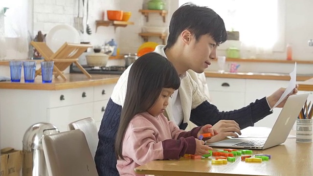 一个韩国爸爸和一个女儿坐在桌子上视频素材画面2