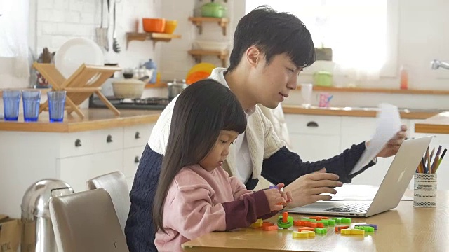 一个韩国爸爸和一个女儿坐在桌子上视频素材画面3
