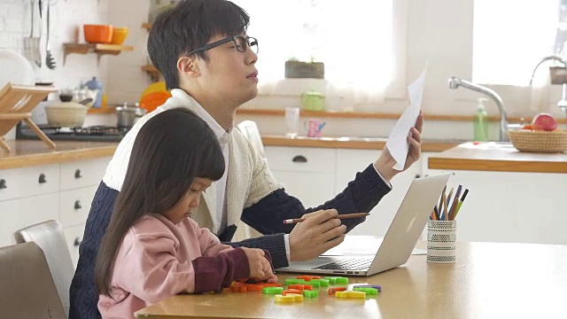 一个韩国爸爸和一个女儿坐在桌子上视频素材画面2