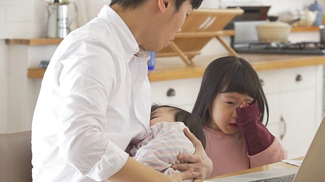 一位韩国父亲抱着一个婴儿试图安慰他哭泣的女儿视频素材画面3