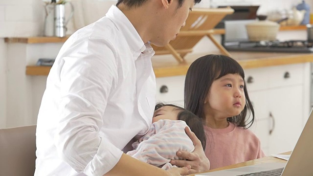 一位韩国父亲抱着一个婴儿试图安慰他哭泣的女儿视频素材画面3