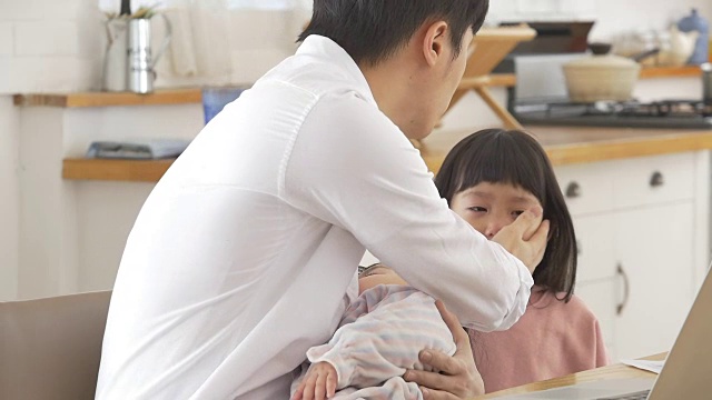 一位韩国父亲抱着一个婴儿试图安慰他哭泣的女儿视频素材画面2