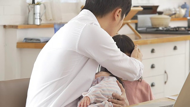 一位韩国父亲抱着一个婴儿试图安慰他哭泣的女儿视频素材画面4