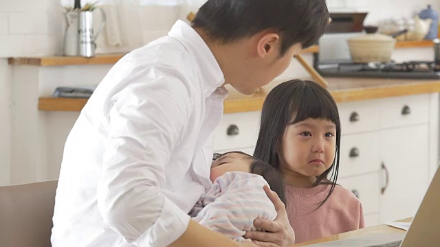 一位韩国父亲抱着一个婴儿试图安慰他哭泣的女儿视频素材画面3