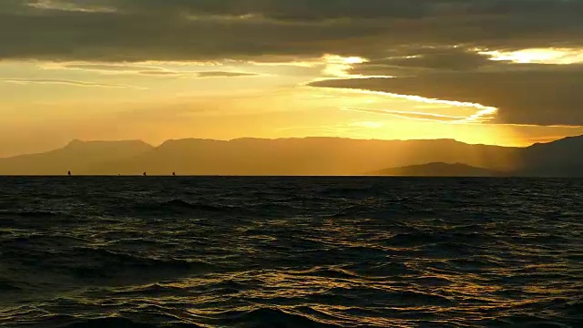 帆船赛在日落时的山海岸的背景视频素材