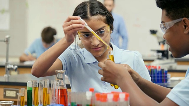 女STEM学院学生用与男实验伙伴进行化学实验视频素材