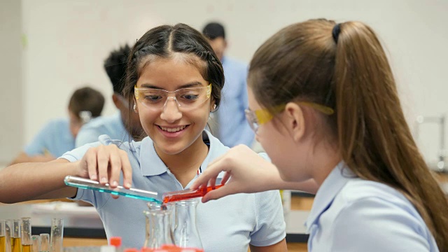 十几岁的女性STEM学校化学实验室合作伙伴进行实验视频素材