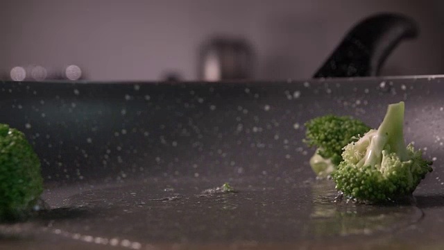 西兰花片放入煎锅的慢镜头，每秒240帧视频素材画面1