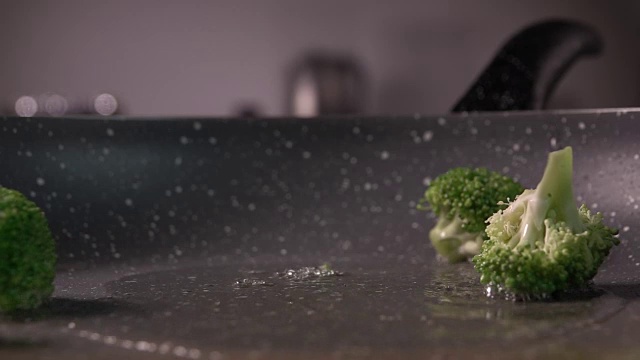 西兰花片放入煎锅的慢镜头，每秒240帧视频素材画面2