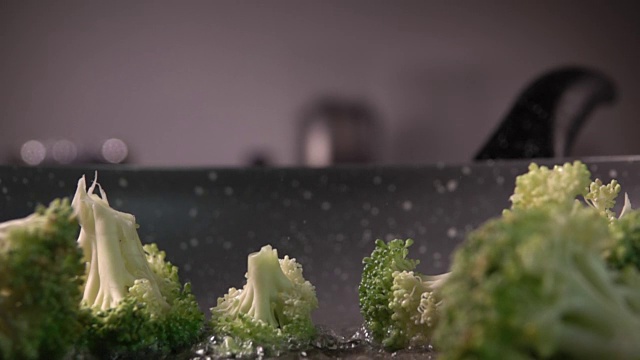 西兰花片从木头上扔进煎锅，每秒480帧视频素材画面1