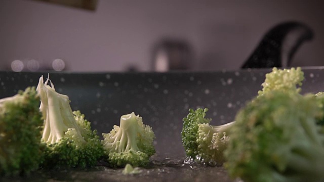 西兰花片从木头上扔进煎锅，每秒480帧视频素材画面2