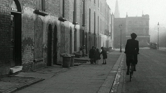 1952年，英国，Wadhurst，蒙太奇区护士从公寓里出来，把医疗包绑到自行车上，骑着车走过街道，路过在人行道上玩耍的孩子们视频素材画面2